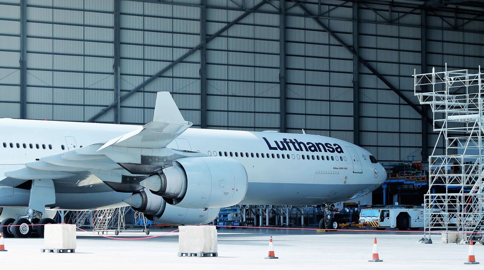 Aircraft maintenance technicians working on a widebody aircraft in a hangar